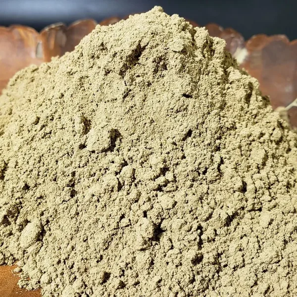 Red Kratom Powder artistically arranged in a wooden leaf-shaped dish, showcasing its rich color and fine granular texture.