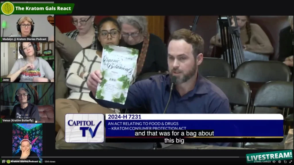 Mike Overstreet from Kratom Guy Show speaking at the Rhode Island KCPA event holding up Christopher's Organic Botanicals Kratom Package for everyone to see. - Kratom Consumer Protection Act