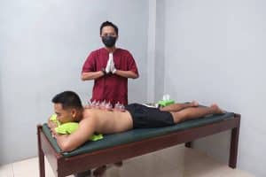 Glass cupping cups creating suction on a person’s back during a traditional Indonesian bekam session